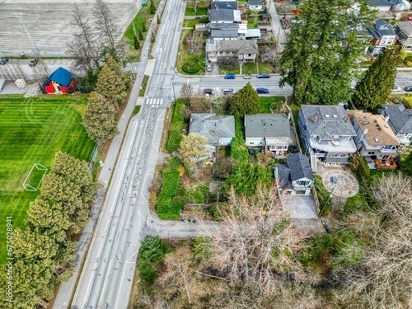 Fototapeta Aerial view of a vibrant suburban neighborhood in North Vancouver, featuring lush trees and greenery