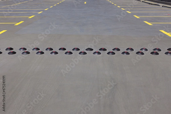 Obraz Speed Bumps On The Road In A Parking Lot