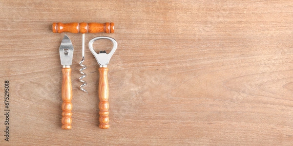 Fototapeta bar set (bottle opener, wine opener, can opener) on wood background with copy space