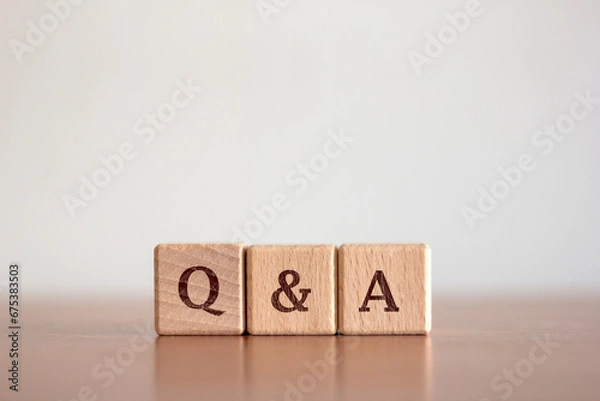 Fototapeta Questions and answers Q&A text on a background of wooden blocks placed on a blurred background table. Business and communication concepts