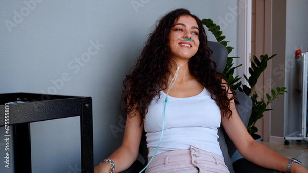 Fototapeta A family sits on a massage chair and breathes in an oxygen mask