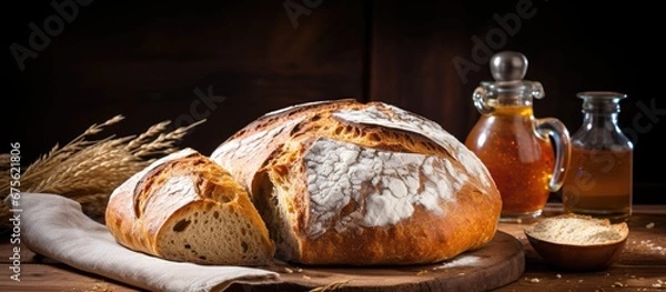 Fototapeta I woke up to the aroma of freshly baked homemade bread from the round loaf with a golden brown crust sitting on the rustic wood background ready for a healthy and delicious breakfast as par