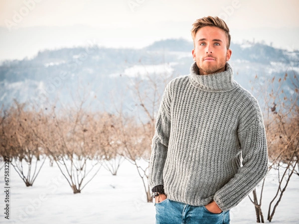 Fototapeta Handsome man in snow posing for camera