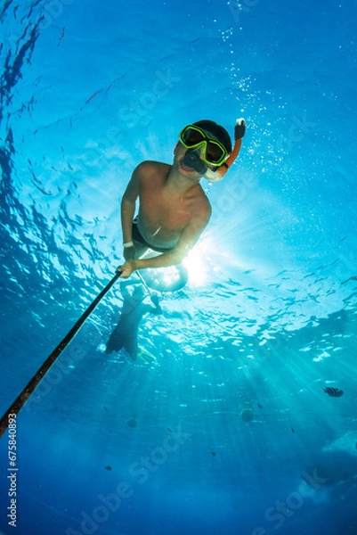Fototapeta Snorkeler on a rope in the Red Sea in Egypt with the sun behind him