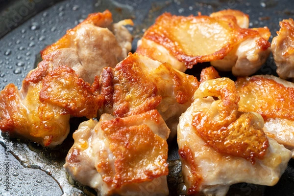 Obraz 地鶏もも肉をフライパンでこんがり焼く調理シーン。
