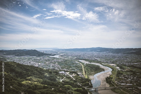 Obraz 梅雨晴れの中、紀の川上空を飛ぶパラグライダーから和歌山市街と和歌山湾を撮影