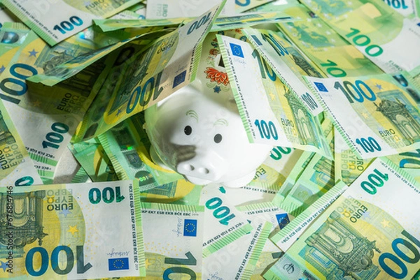 Obraz Money pig on the background of money bills of 100 euros covered with bills sticking out nose