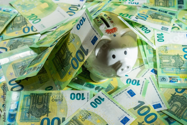 Obraz Money pig on the background of money bills of 100 euros, center ange view on piggy bank covered with money banknotes
