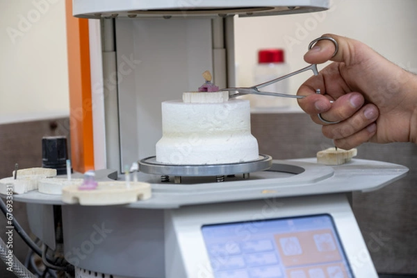 Fototapeta Crowns oven with crown on gypsum holder with humans to prevent heat burns using holder
