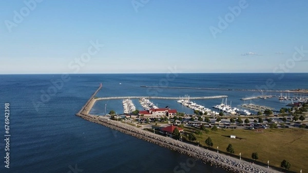 Obraz Aerial shot of the sea with piers and boats in the harbor under the clear sky