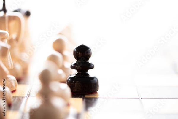 Fototapeta anymore in your game.
Black pawn moving away from the white pieces, close up