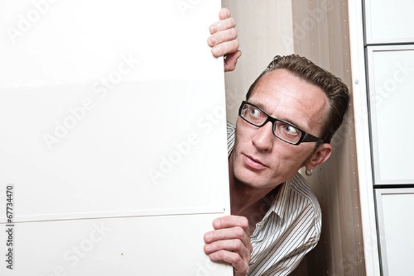 Obraz Surprised man inside white wardrobe  Copy space left