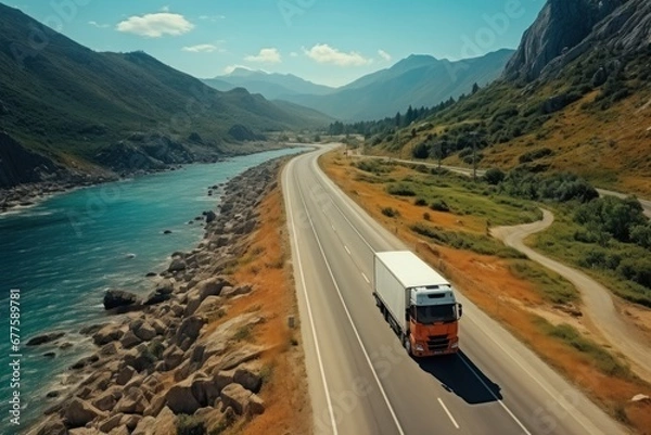 Fototapeta white truck driving on asphalt road on the highway. seen from the air. Aerial view landscape. drone photography. cargo delivery