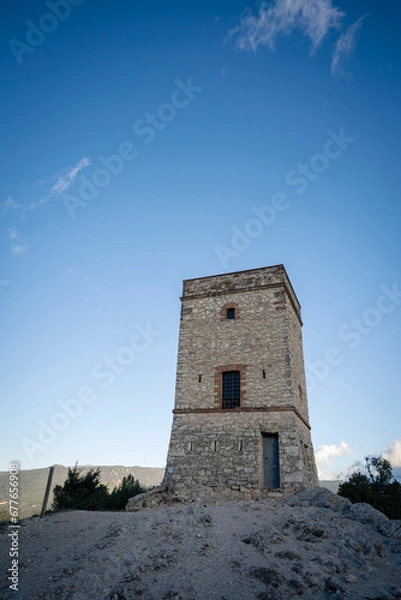 Fototapeta Ancient Stone Telegraph Tower in the Shadows and Stone Path at Puigracios, Catalonia