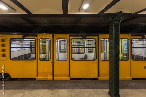 Obraz Yellow metro car in underground subway station on the M1 line