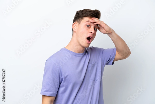 Fototapeta Young handsome Brazilian man isolated on white background doing surprise gesture while looking to the side