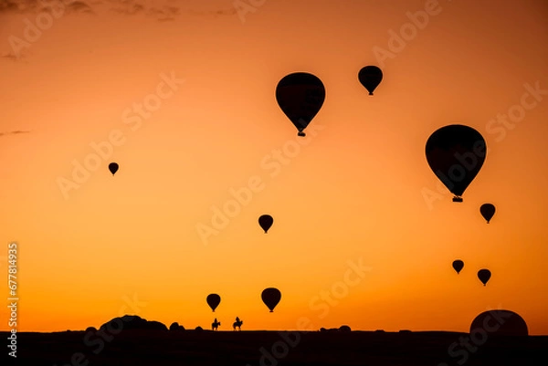 Fototapeta Air balloons at sunset over Cappadocia-Goreme, Turkey, Oct. 20th,2022. A vibrant explosion of light and color, and the enthusiasm of flying an air balloon over the strange rock formation.
