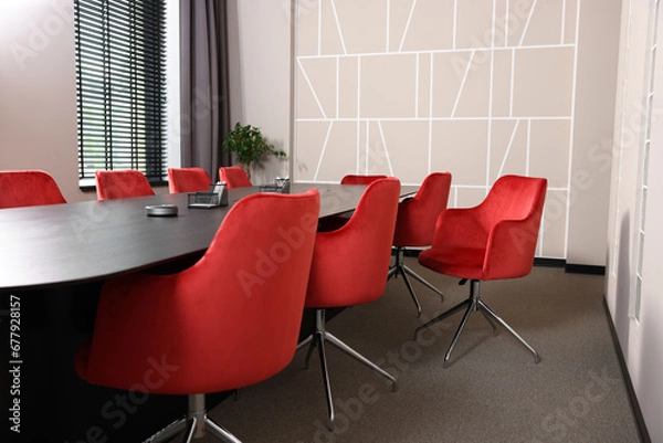 Fototapeta Stylish red office chairs and large wooden table in empty conference room