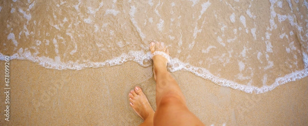 Fototapeta A beautiful girl in a bikini on a wild beach, bathing in the clear waves of the warm sea. a heavenly place and a beautiful model.