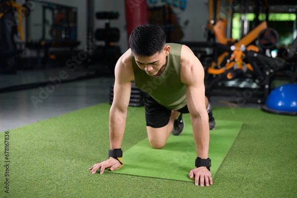 Obraz Asian man who keeps fit by doing push-ups Build strength in the chest muscles. Health workout concept