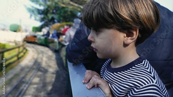Obraz Observant Child Enjoying View, Leaning from Moving Miniature Train Wagon at Swiss Vapeur Park