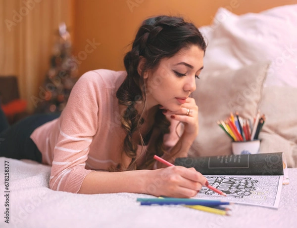 Fototapeta Girl drawing and coloring in a coloring book