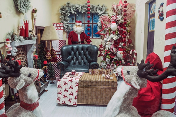 Fototapeta  A colorful, joyful scene adorned with a Santa statue, plush sofa, and charming stuffed animals. Perfect for holiday-themed projects.