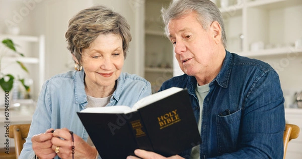 Fototapeta Bible study, reading and senior couple in home with Christian worship, prayer and education in faith. Elderly, people and studying holy gospel, religion or trust in God and together in retirement