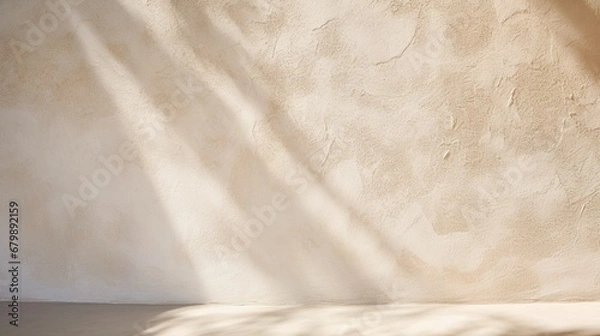Fototapeta A close-up view of a stucco-textured exterior wall with rough, earthy texture, capturing the interplay of light and shadows on its surface.