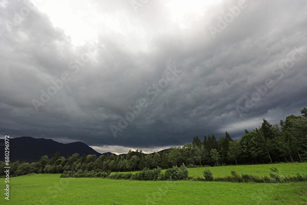 Obraz Dunkle Regenwolken über einer grünen Wiese