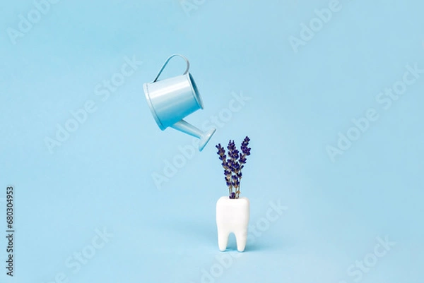Fototapeta A white tooth and a watering can on a blue background. Close up. Dental health concept. Flat lay. Stomatology. Place for text. Oral health and dental inspection teeth. Dentistry. Concept fresh breath