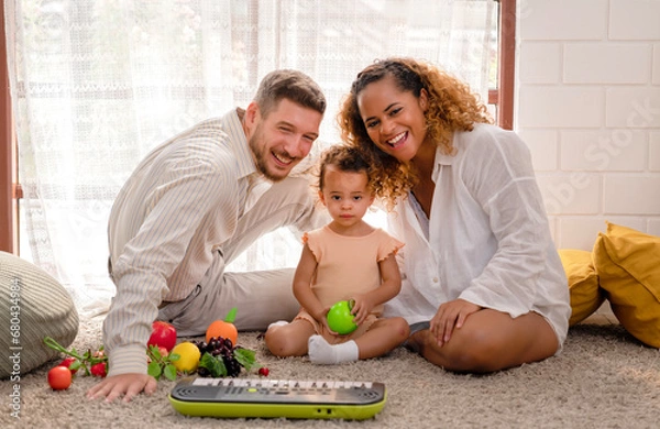 Fototapeta Portrait of happy family plays with kid in living room with diversity fruit toys on the floor at home, relaxing time to play with little child for developing remember brain, muscles, colors and focus