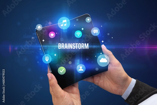 Fototapeta Businessman holding a foldable smartphone