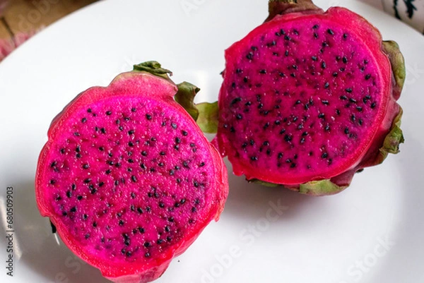 Obraz Red Dragon fruit slice and cut half on white plate.