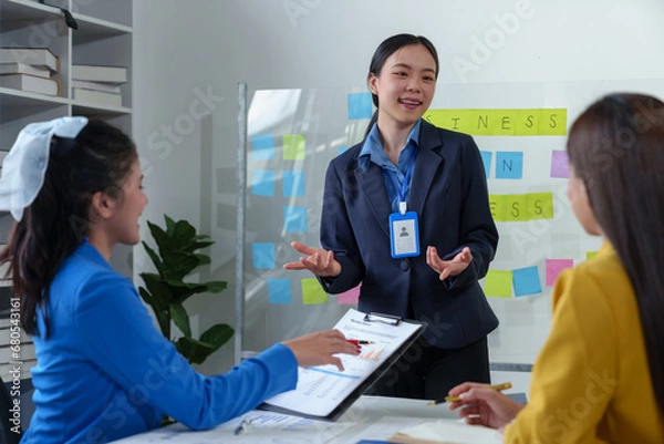 Fototapeta Group of colleagues, Asian businesswomen presenting and explaining investment project reports and planning strategies Budget calculation, business growth report on company laptop.