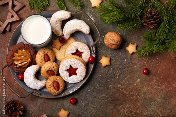 Fototapeta Christmas cookies and milk for Santa: linzer cookies with strawberry jam, crescents with sugar powder, almond cookies, chocolate cookies with condensed milk. Top view, blank space for text