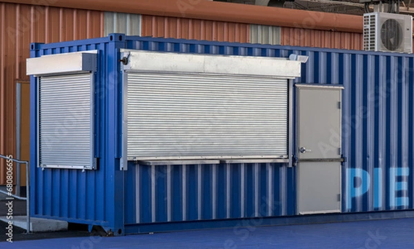 Fototapeta shuttered concession stand (ticket booth) closed for the season, metal gate lowered (shipping container construction) shutters