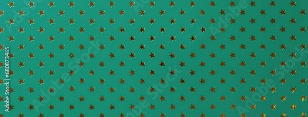 Fototapeta Dark green background from metal foil paper with a golden stars pattern.