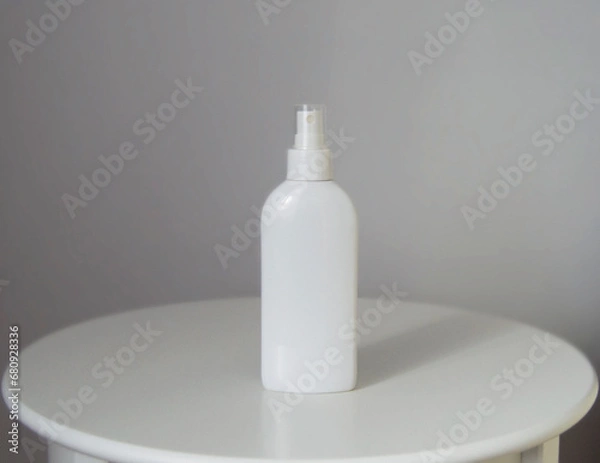 Fototapeta White cosmetic spray bottle mockup on white table and grey background. Sun rays. Shadow.
