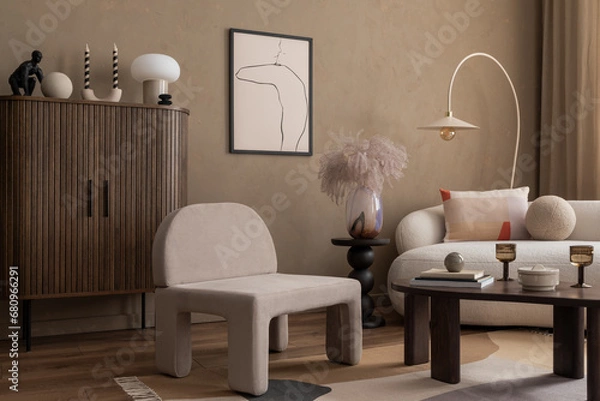 Fototapeta Warm and cozy composition of living room interior with mock up poster frame, boucle sofa, gray armchair, wooden sideboard, vase with dried flowers and personal accessories. Home decor. Template.
