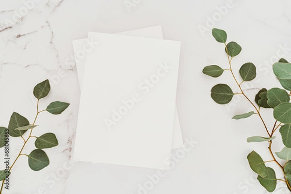 Fototapeta Empty blank white magazine cover mock up and green eucalyptus branch on white marble table background.