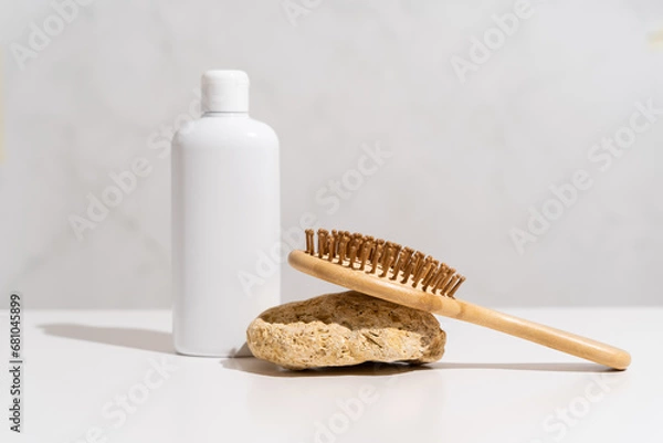 Fototapeta White plastic bottle mock up, used for shampoo and conditioner and hair wood comb on white background