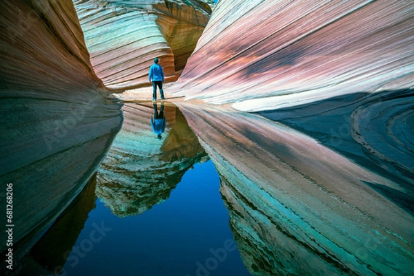 Fototapeta A man standing in the Wave. The Wave is an amazing natural feature found in the northern section of Coyote Buttes about mid-way between Page, Arizona and Kanab, Utah. 