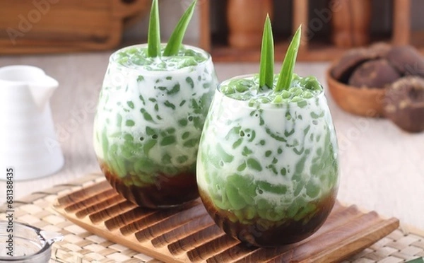 Fototapeta Cendol is a sweet dessert that contains droplets of green rice flour jelly, coconut milk and palm sugar syrup. It is served with shaved ice and is a refreshing snack in hot weather. 