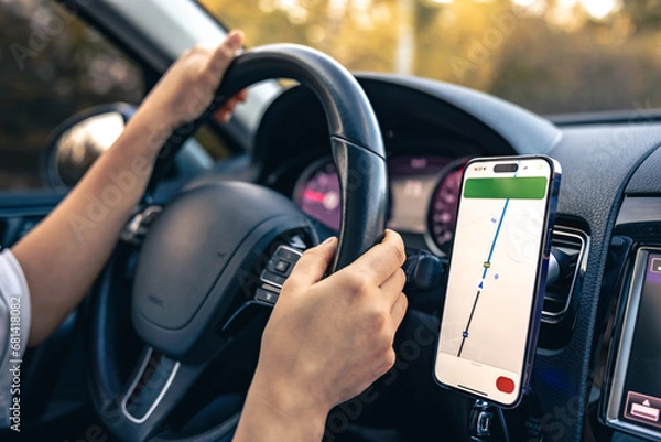 Fototapeta Woman using navigation app on smartphone while driving a car.