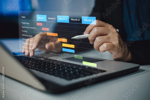 Fototapeta Project manager working and update tasks with milestones progress planning. Businessman using laptop computer plan schedule virtual diagram, business project management concept.