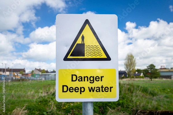 Fototapeta Danger Deep Water warning sign close up by rural waterway river stream. 