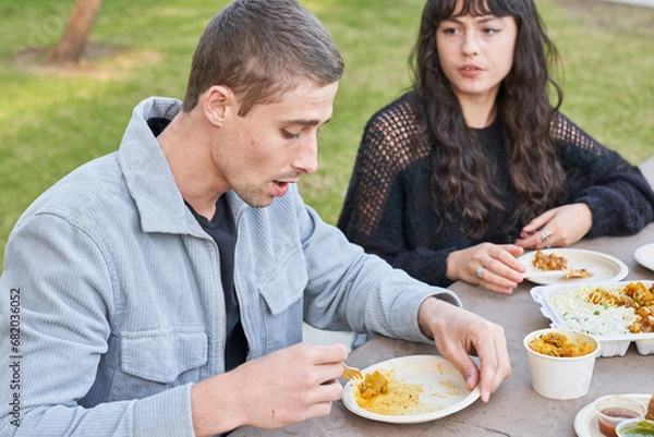 Obraz Couple eats Indian food at picnic table