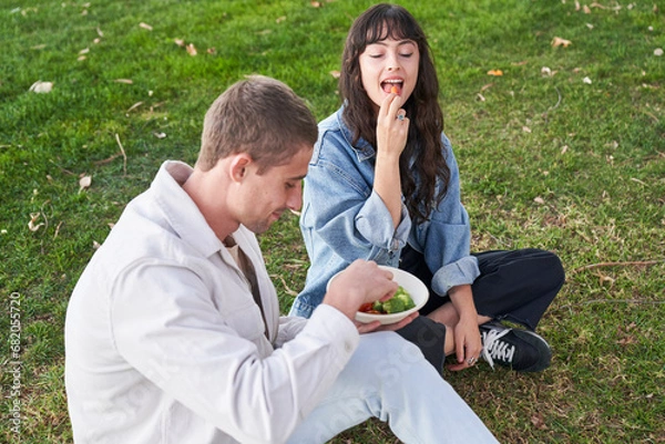 Obraz Couple eats vegetables in park