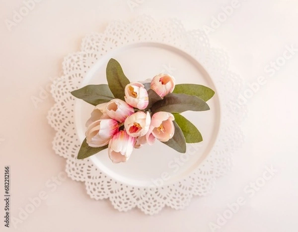 Obraz Tulips and a white plate. Green leaves
